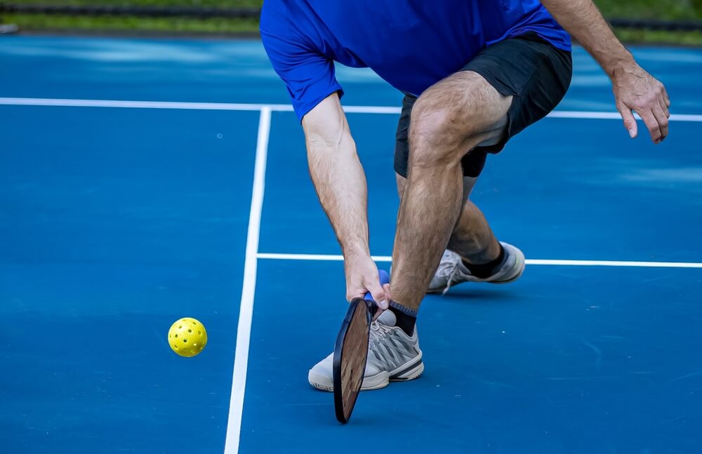 A man being active on the pickleball court which can result in foot injuries like Plantar Fasciitis with the explosive movements of the game