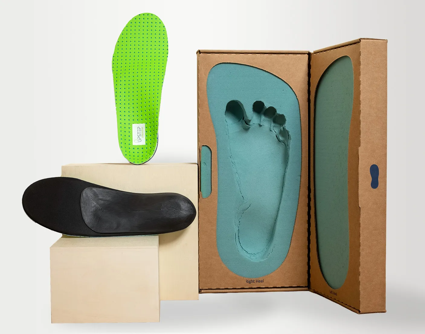 Upstep's insoles in green color next to the kit for leaving footprint for custom made orthotics.