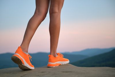 Person wearing orange trainers standing on a mountain