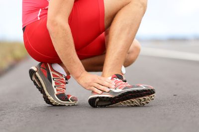 An athlete massaging foot - returning to running after foot fracture