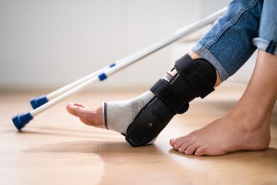 Foot wrapped in bandages next to crutches