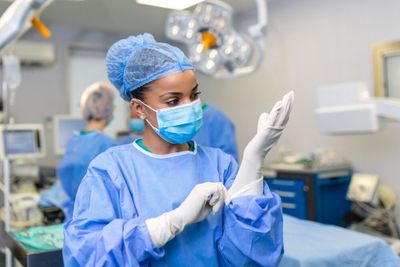 A surgeon applying her gloves prior to surgery.