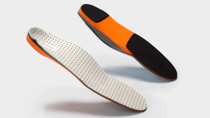 Pair of orange custom orthotics on displaying, showing both the front and back