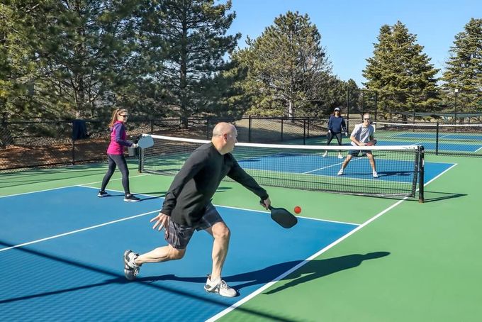 People laying pickleball on the court to get better at the game.