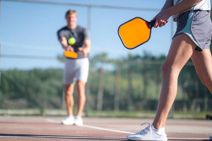 Preventing pickleball injuries: a couple playig a match on the court.