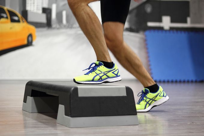 A close-up of a man doing step ups to help with runner's knee