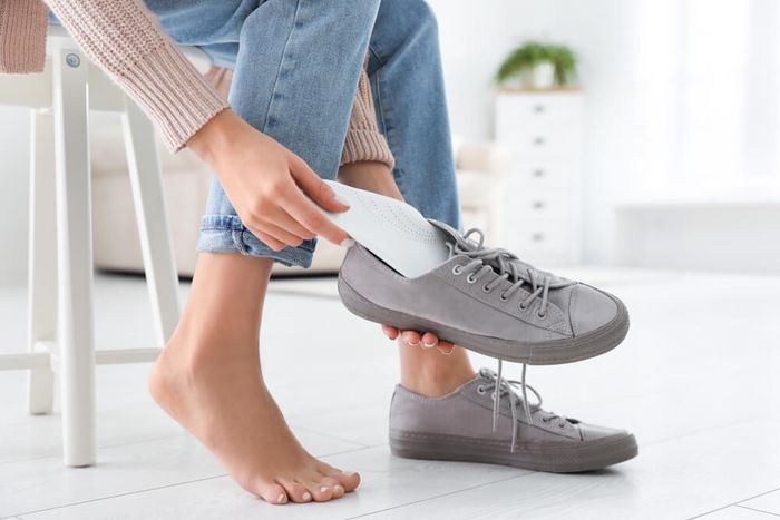 A woman using insoles for her shoes that help correct gait imbalances, among other foot-related issues.