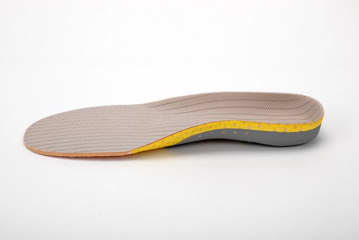 One custom supination insole from Upstep resting against a white background.