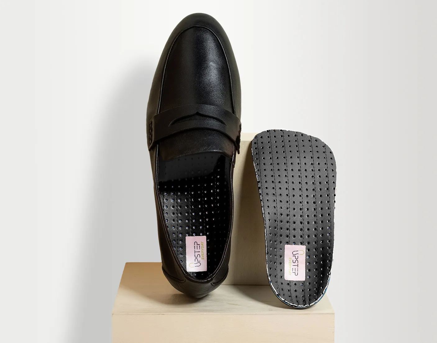 Upstep's On My Feet All Day shoe orthotics presented in a pair of black leather shoes.