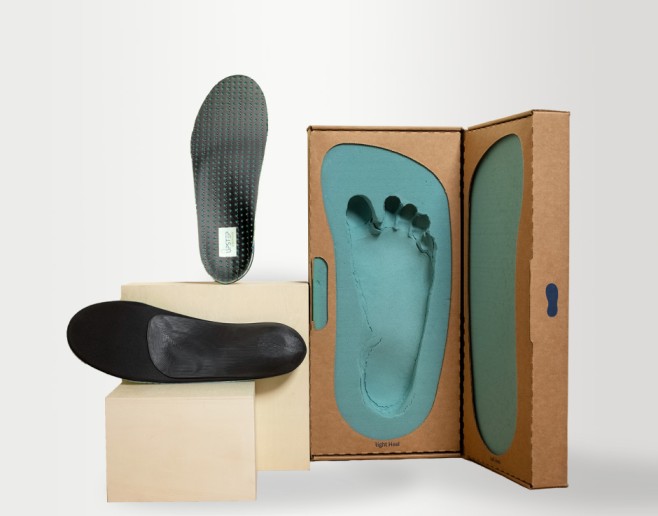 A shoe and a black upstep custom insole for plantar fasciitis next to an insole mold