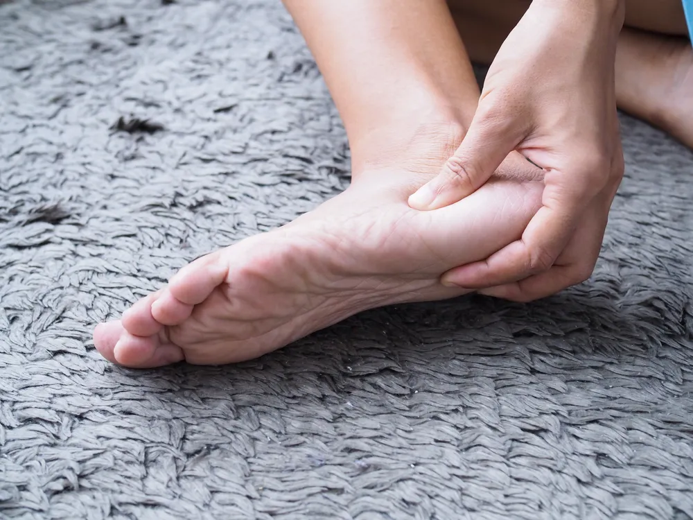 A person massaging their heel to relieve pain 